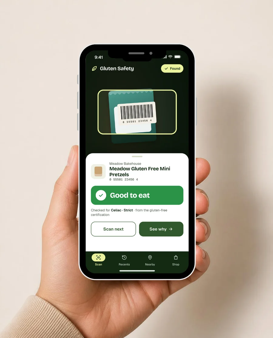 A hand holding a phone showing Gluten Safety scanning a barcode with a green Good to eat result